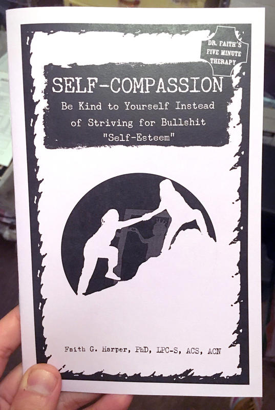 the self-compassion zine, the cover featuring a person helping another person climb a steep hill